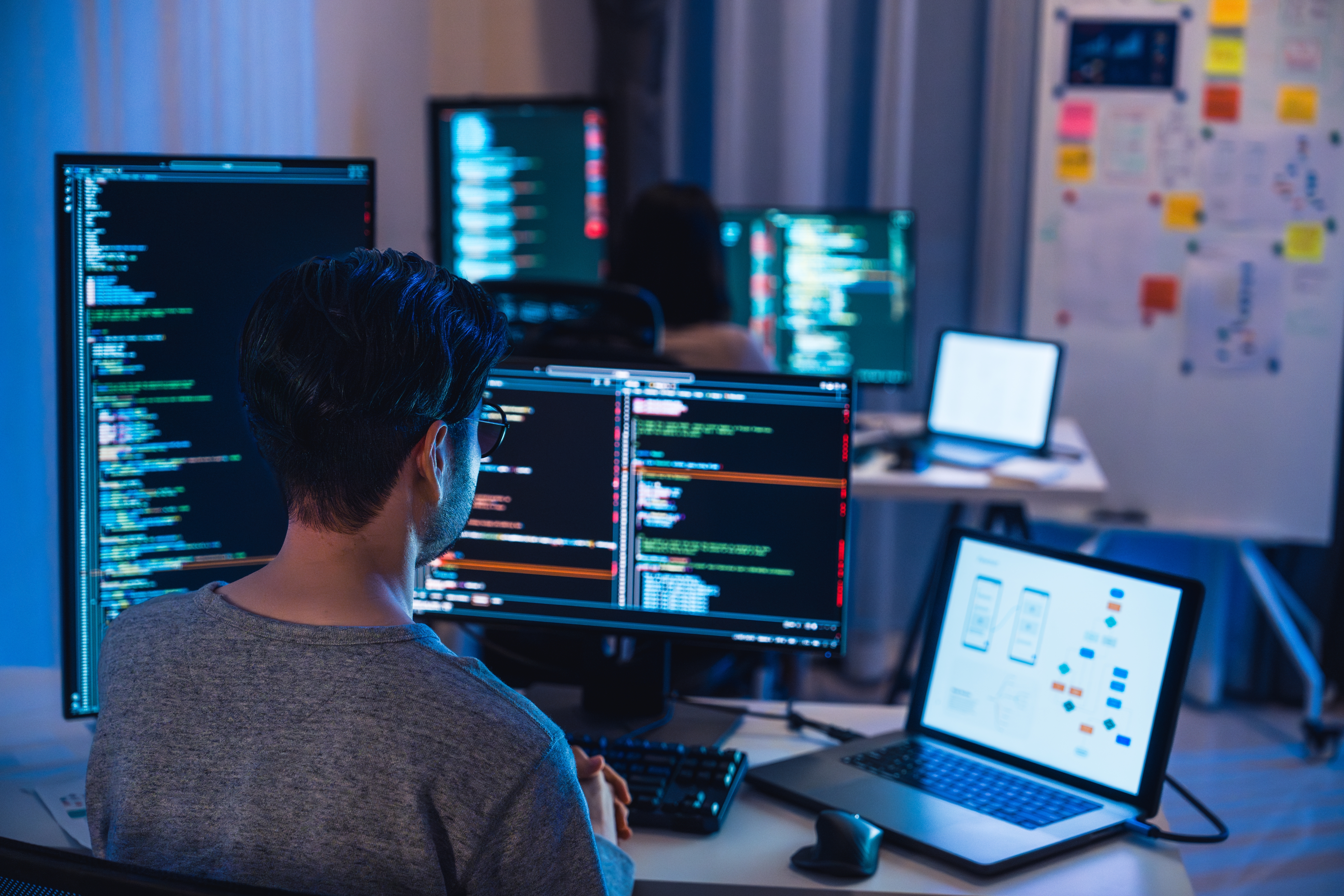 programmer in front of several monitors